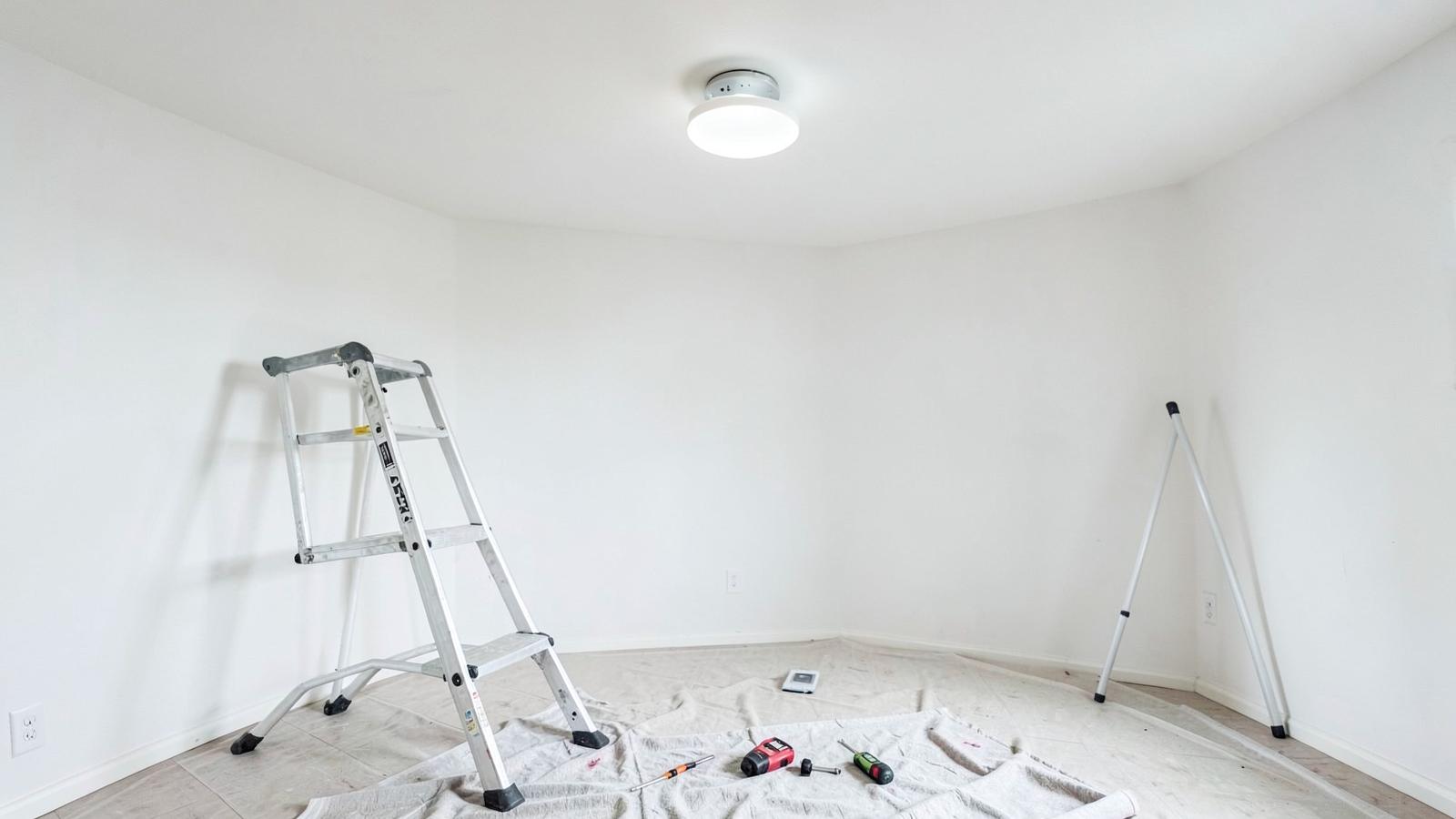 New ceiling light above a stable ladder and neatly arranged electrical tools